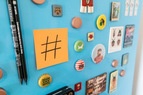Blue fridge with magnets and a sticky note with a hashtag